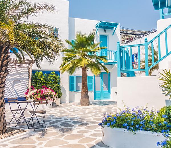 Weiße Gebäude mit Palmen vor der Türe im schönen Santorini auf Europa Kreuzfahrt mit Princess Cruises.  